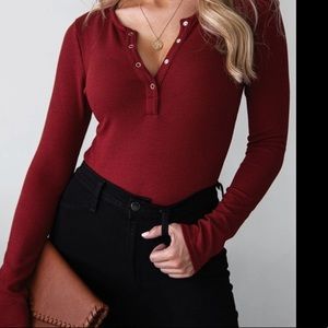 Long sleeved burgundy body suit with buttons.